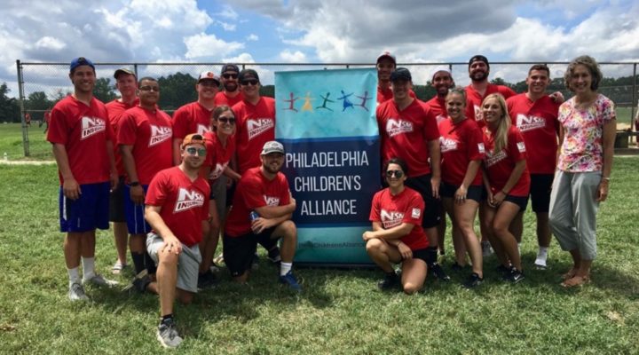 Group of NSM employees holding sign Philadelphia Children's Alliance